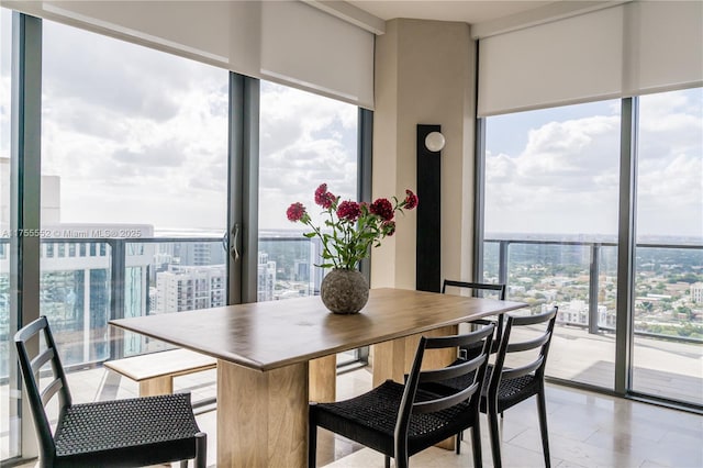 dining room featuring light tile patterned floors, floor to ceiling windows, and a city view