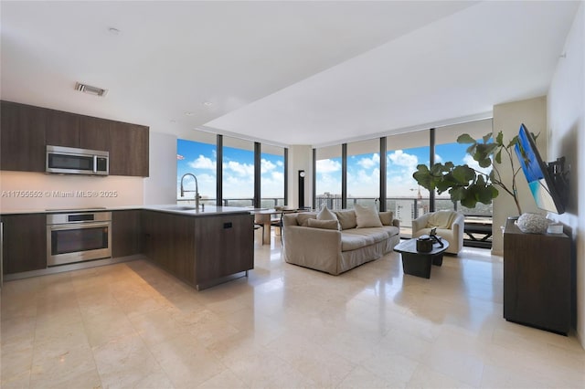 kitchen with appliances with stainless steel finishes, floor to ceiling windows, visible vents, and modern cabinets