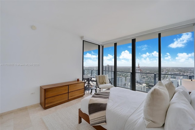 bedroom with a view of city and a wall of windows