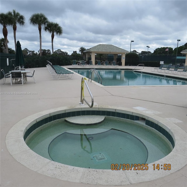 pool featuring a gazebo, a hot tub, and a patio