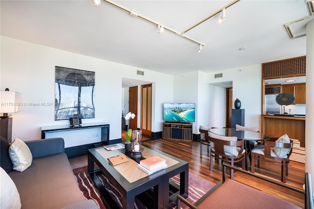 living room featuring track lighting, visible vents, and wood finished floors