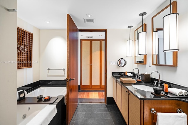 bathroom with double vanity, visible vents, a sink, and a bath