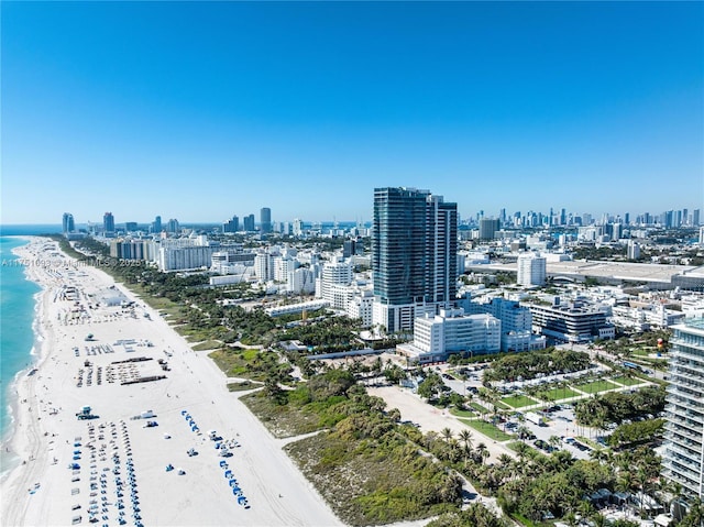 bird's eye view with a water view, a view of the beach, and a city view