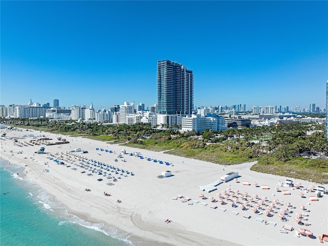 drone / aerial view featuring a view of the beach, a city view, and a water view