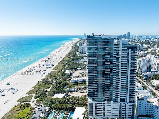 birds eye view of property with a water view, a beach view, and a city view