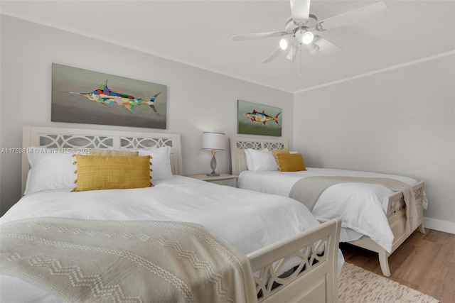 bedroom featuring ceiling fan, crown molding, and wood finished floors