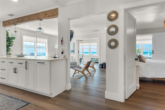 kitchen with a healthy amount of sunlight, visible vents, dark wood finished floors, and beamed ceiling