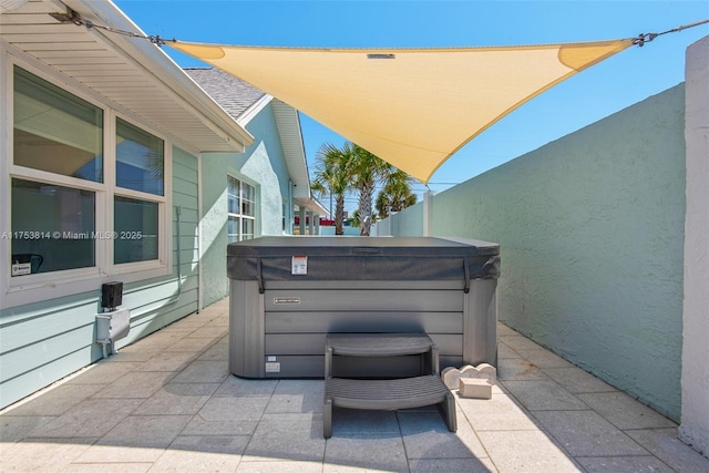 view of patio featuring a hot tub and fence