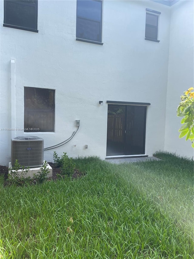 back of property featuring stucco siding and central air condition unit