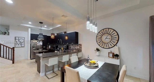 dining room with baseboards, visible vents, a raised ceiling, and recessed lighting