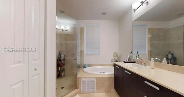 bathroom with a garden tub, a shower stall, visible vents, and vanity