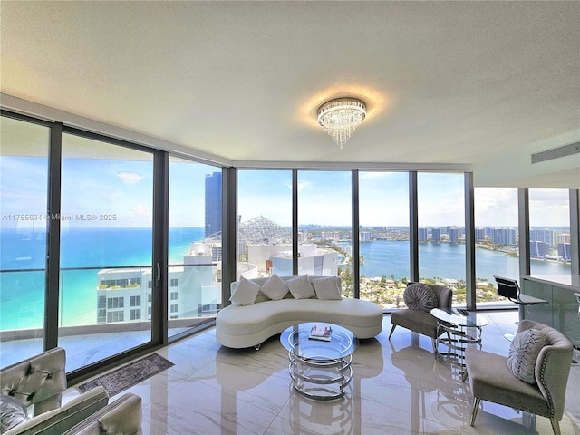 18975 Collins Ave Unit 3504, Sunny Isles Beach, FL 33160 - living room featuring floor to ceiling windows, a water view, healthy amount of natural light, a chandelier, and light marble finish flooring