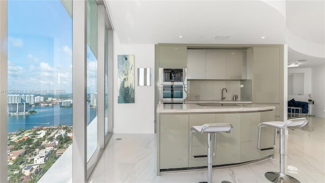 18975 Collins Ave Unit 3504, Sunny Isles Beach, FL 33160 - kitchen featuring gray cabinetry, oven, modern cabinets, light marble finish floors, and a water view