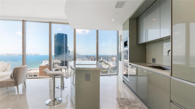 18975 Collins Ave Unit 3504, Sunny Isles Beach, FL 33160 - kitchen with modern cabinets, oven, a water view, expansive windows, and light countertops