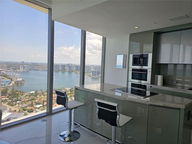18975 Collins Ave Unit 3504, Sunny Isles Beach, FL 33160 - kitchen featuring a water view, expansive windows, healthy amount of natural light, modern cabinets, and black electric stovetop