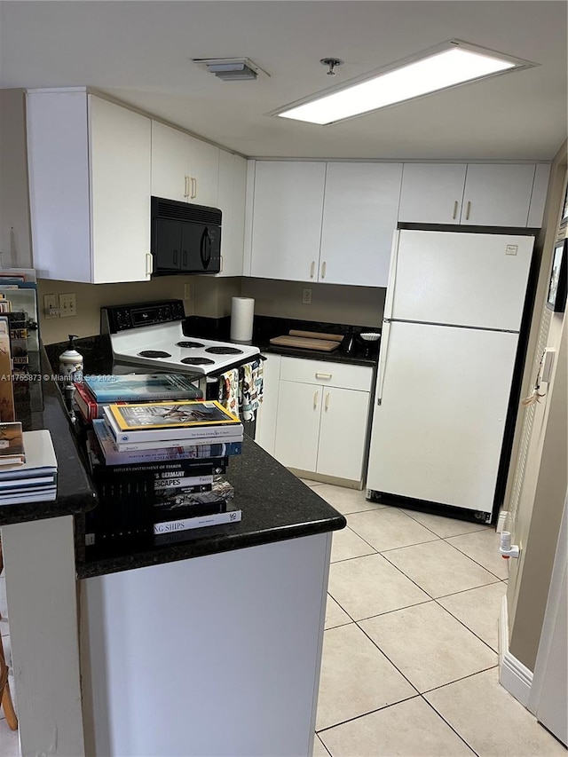2351 Douglas Rd Unit 1109, Miami, FL 33145 - kitchen with white appliances, dark countertops, white cabinets, and light tile patterned floors