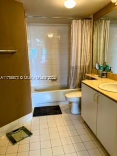 bathroom with shower / tub combo, vanity, toilet, and tile patterned floors