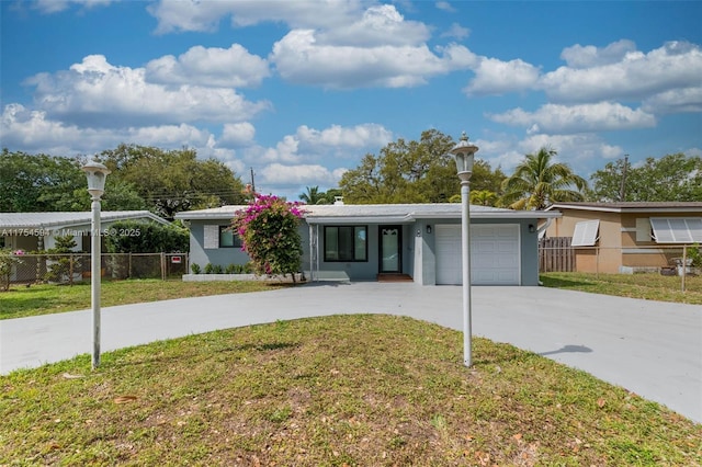 view of front of property with a garage, driveway, a front lawn, and fence