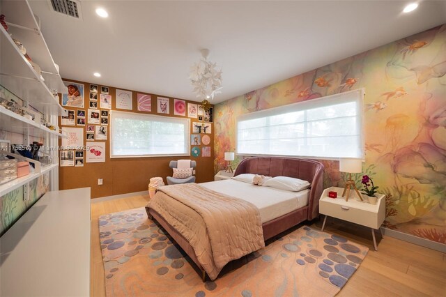 bedroom with recessed lighting, wood finished floors, visible vents, baseboards, and wallpapered walls