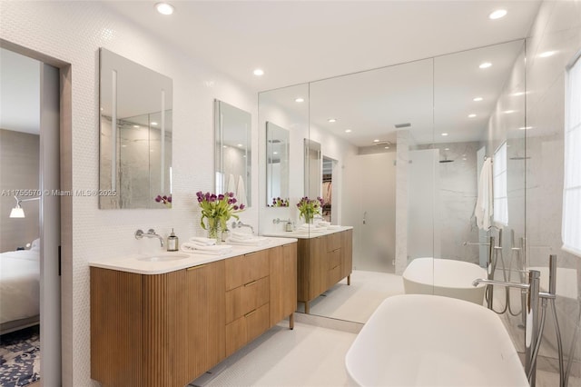 full bath featuring double vanity, recessed lighting, a stall shower, a sink, and a freestanding bath