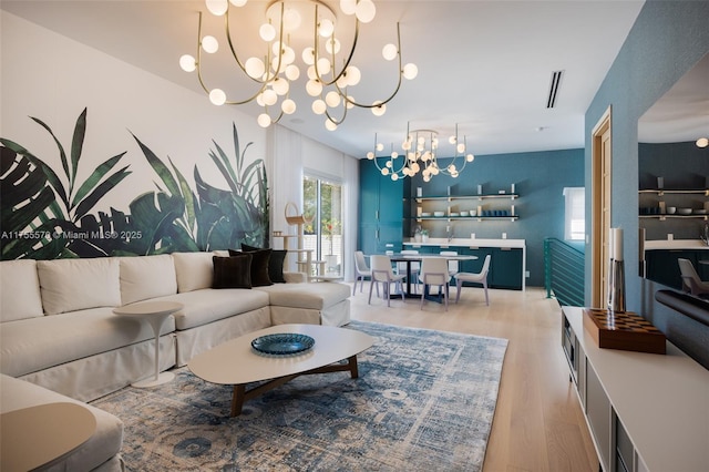 living room featuring a chandelier, visible vents, and light wood-style flooring