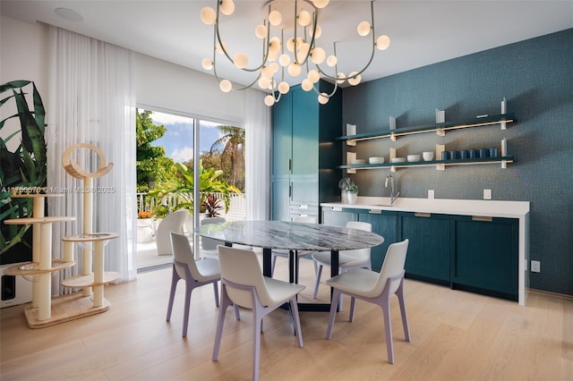 dining space with light wood-style floors and a chandelier