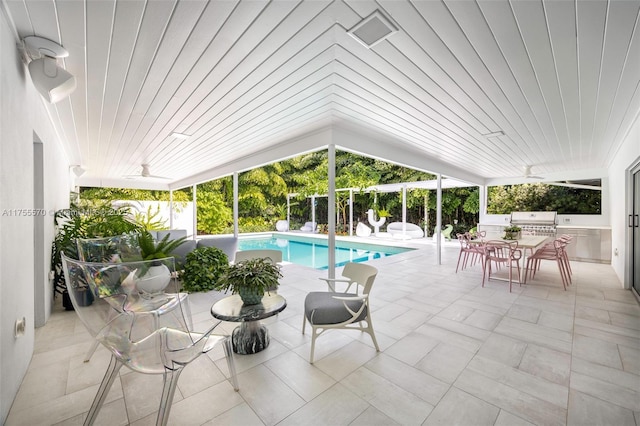 outdoor pool with area for grilling, ceiling fan, a grill, and a patio