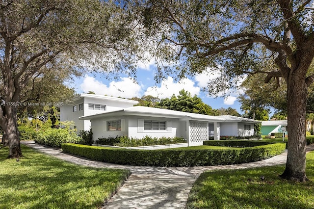 view of front facade with stucco siding and a front lawn