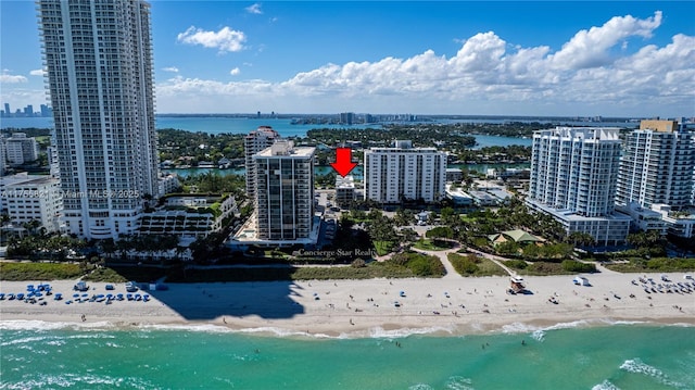 drone / aerial view featuring a beach view, a water view, and a city view