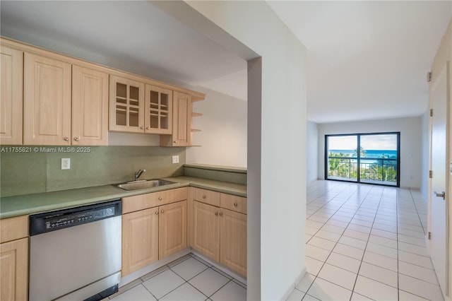 kitchen featuring dishwasher, light brown cabinetry, a sink, and glass insert cabinets