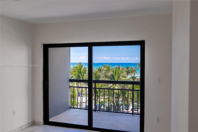 entryway featuring a wealth of natural light, a water view, and light tile patterned floors