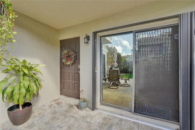 property entrance with stucco siding