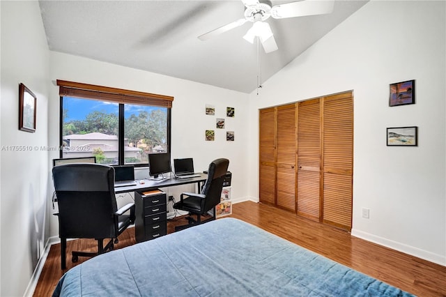 bedroom with a closet, baseboards, vaulted ceiling, and wood finished floors