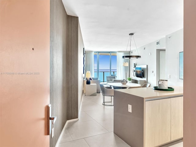 kitchen with light tile patterned floors, open floor plan, light countertops, light brown cabinetry, and modern cabinets