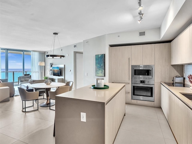 kitchen featuring open floor plan, stainless steel appliances, modern cabinets, and light countertops