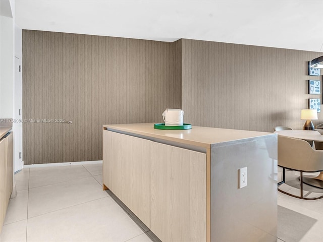 kitchen with light tile patterned floors, light countertops, light brown cabinets, a kitchen island, and modern cabinets