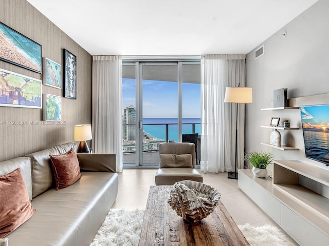 living area featuring expansive windows, tile patterned flooring, and visible vents