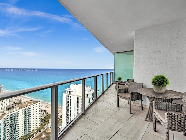 balcony featuring a water view and a view of the beach