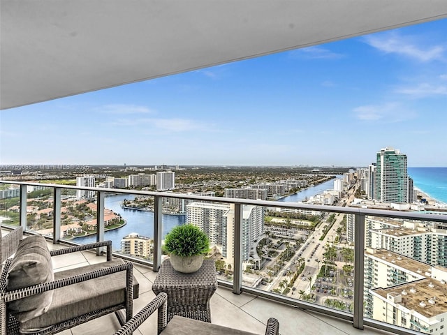 balcony with a water view and a view of city