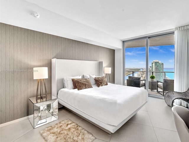 tiled bedroom featuring access to outside and a wall of windows