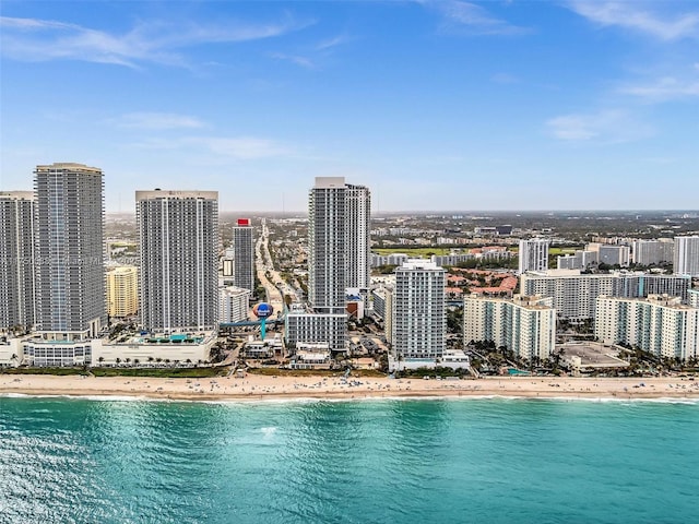 aerial view featuring a city view, a water view, and a beach view