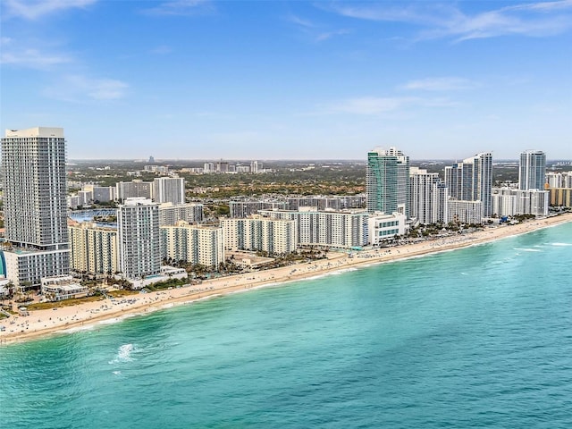 birds eye view of property featuring a water view, a view of city, and a view of the beach