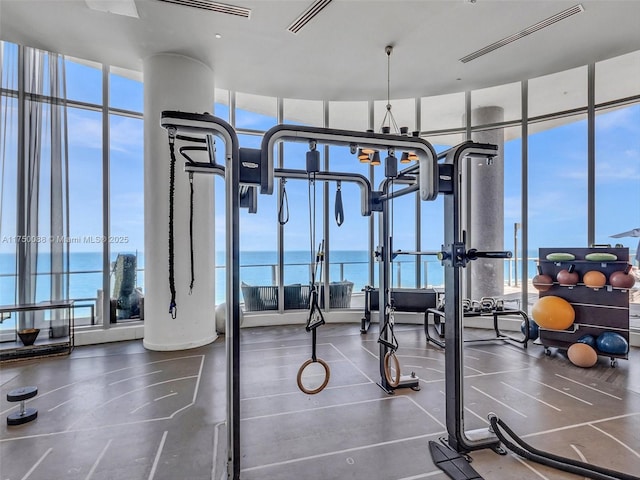 gym with a water view, floor to ceiling windows, and visible vents