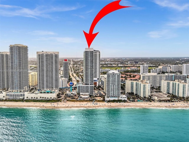 drone / aerial view featuring a view of city, a water view, and a view of the beach