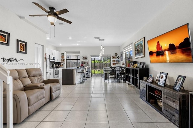 living area featuring light tile patterned floors, ceiling fan, visible vents, and recessed lighting