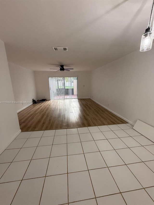 unfurnished room featuring tile patterned flooring, visible vents, and ceiling fan