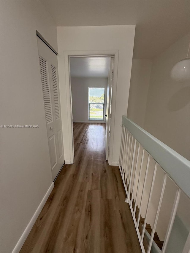 hallway with wood finished floors and baseboards