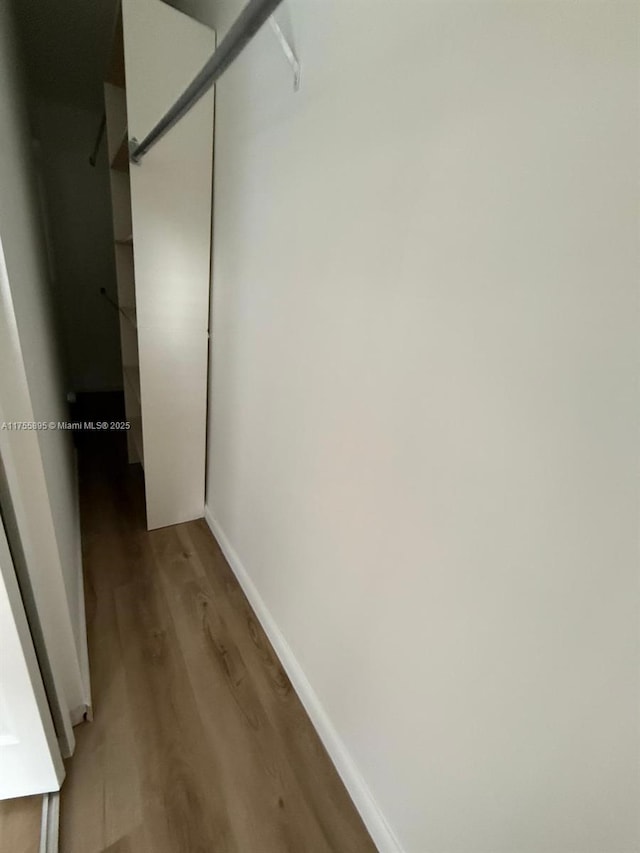 hallway featuring baseboards and light wood-style floors