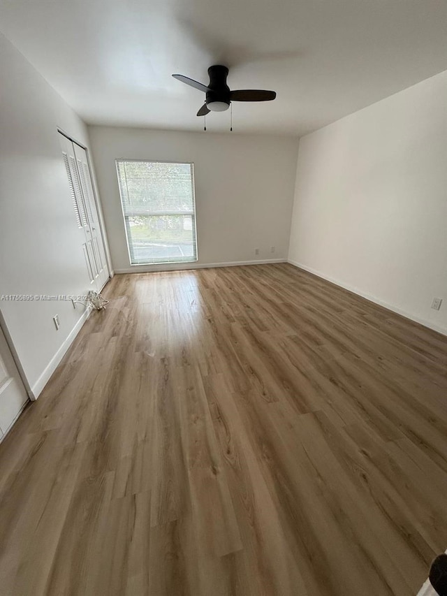 interior space with wood finished floors, baseboards, and ceiling fan