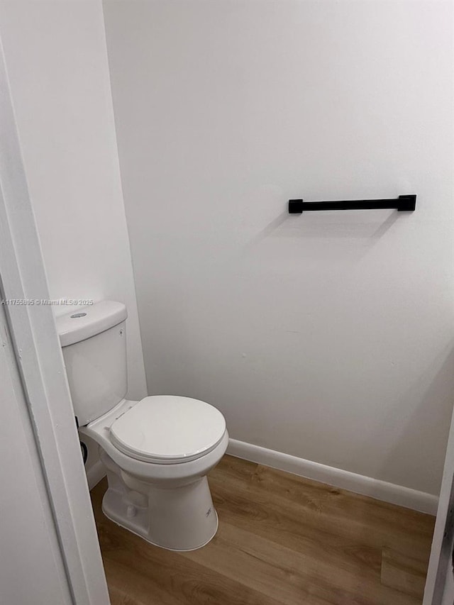 bathroom featuring baseboards, toilet, and wood finished floors